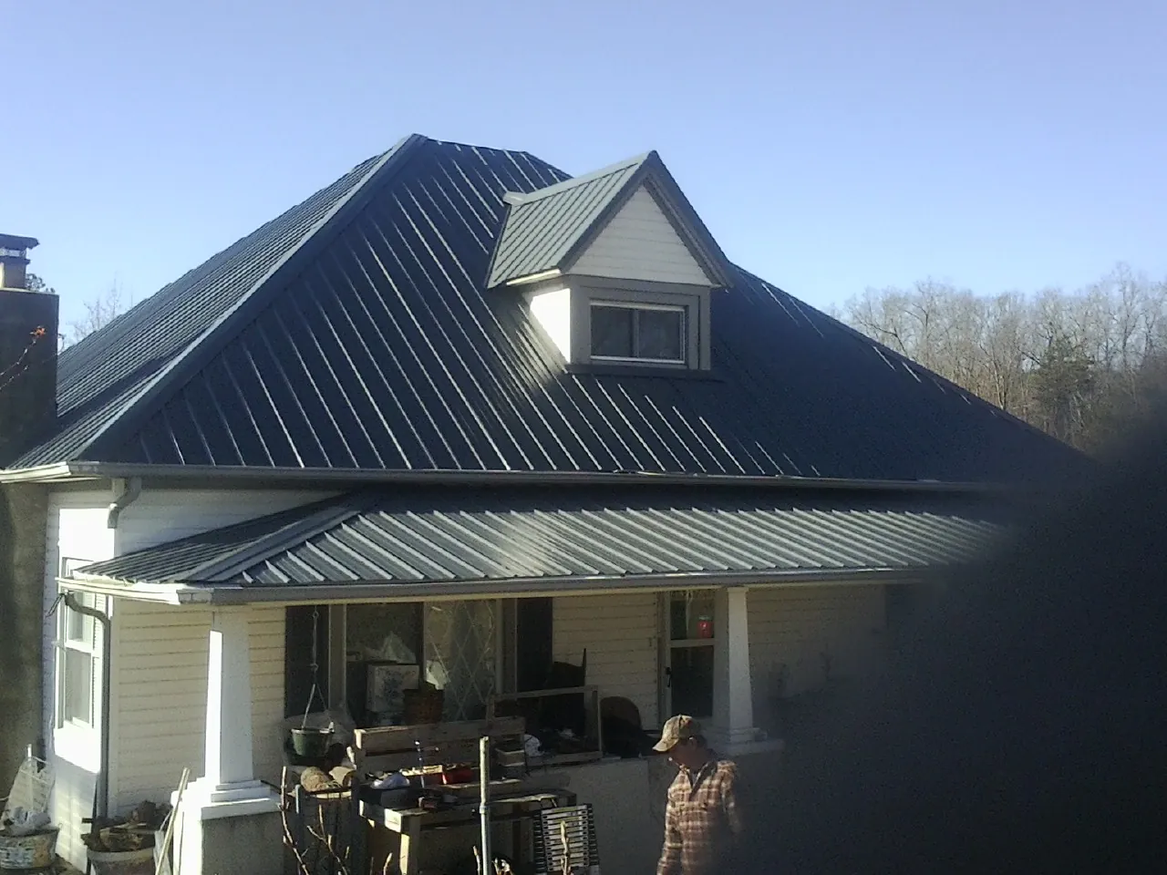 Dark blue standing seam metal roof with a dormer above a front porch in Millington
